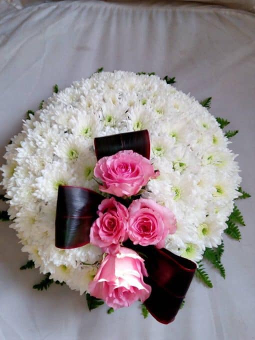 White circular wreath with pink rose spray